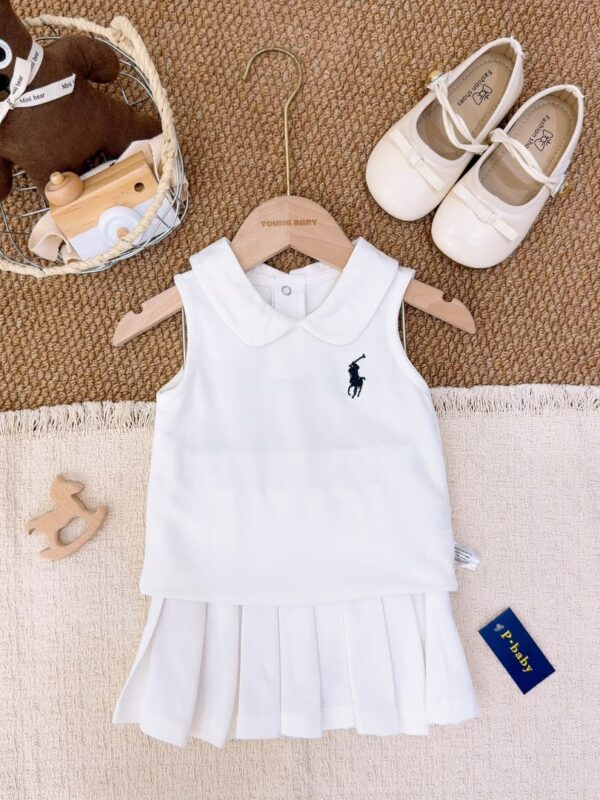 White sleeveless Peter Pan collar top layered over a white pleated skirt, with a dark horse-and-rider motif on the chest.
