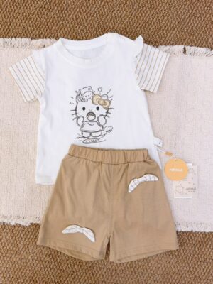 White cartoon-cat short-sleeve top with beige-brown striped sleeves, paired with khaki shorts featuring striped bow details.