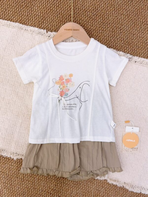 White elephant-and-bouquet short-sleeve top with a white bow, paired with grey-khaki pleated shorts with ruffled hems.