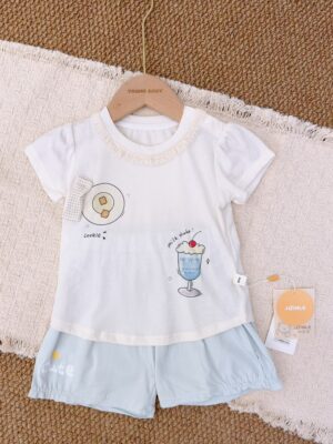 White lace-trimmed round-neck top with cookie and blue milkshake prints, paired with pale blue shorts featuring a star and lettering.