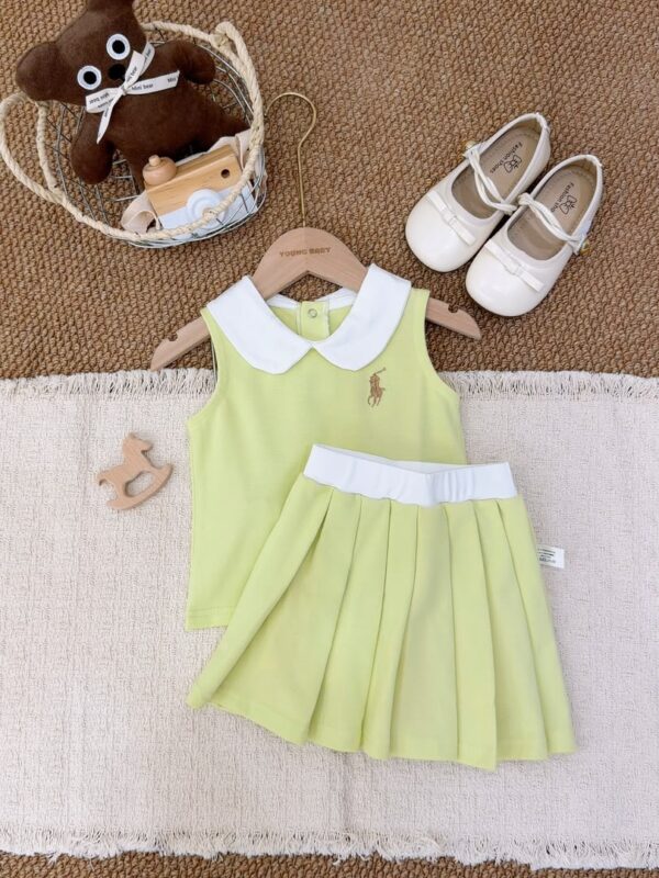 Yellow-green sleeveless top and pleated skirt laid flat, with a white Peter Pan collar, white waistband and a brown-gold horse-and-rider chest motif.