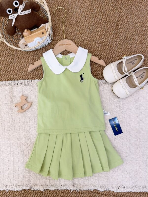Light green sleeveless top layered over a matching pleated skirt, with a white Peter Pan collar and a dark horse-and-rider chest motif.