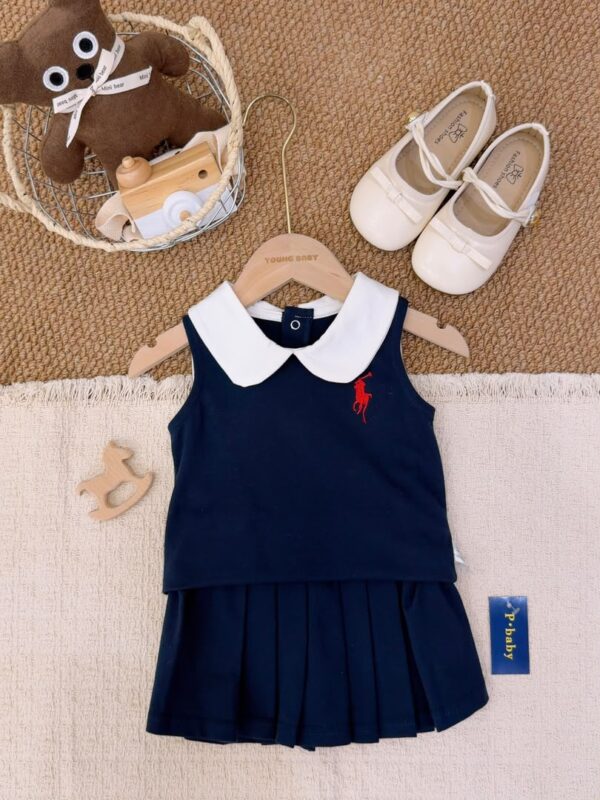 Navy sleeveless top layered over a matching pleated skirt, with a white Peter Pan collar and a red horse-and-rider chest motif.