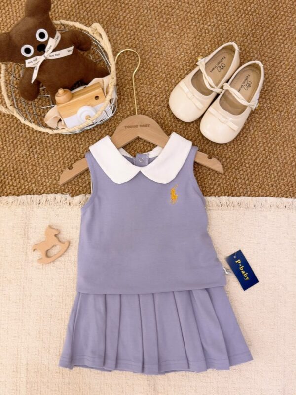 Light purple sleeveless top layered over a matching pleated skirt, with a white Peter Pan collar and a golden-yellow horse-and-rider chest motif.