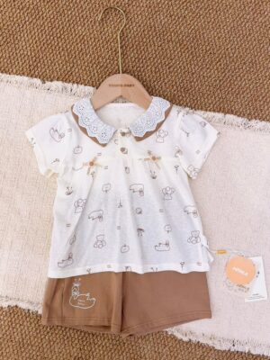 Ivory short-sleeved top with animal and fruit line drawings, a brown-and-white embroidered collar and small flower-and-bow decorations, paired with brown shorts featuring a white swan graphic.