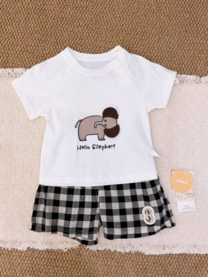 White raglan short-sleeved top with an elephant graphic, brown fabric ear details and Hello Elephant lettering, paired with black, grey and white checked shorts.