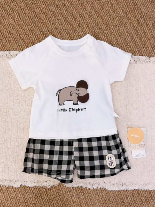 White raglan short-sleeved top with an elephant graphic, brown fabric ear details and Hello Elephant lettering, paired with black, grey and white checked shorts.