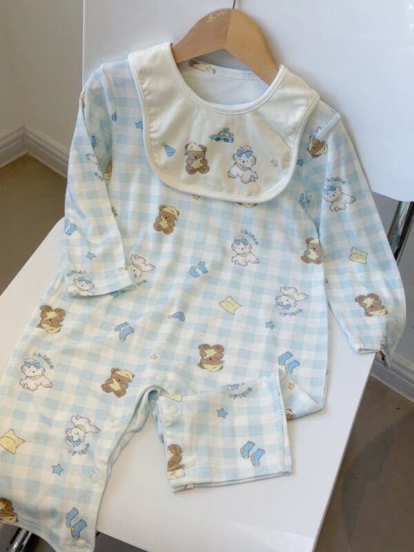 Blue-and-white checked long-sleeved romper with a cream bib, featuring bears, dogs and stars, with visible snaps along the inner legs.