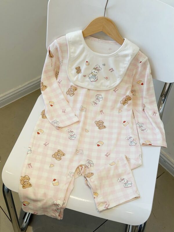 Pink-and-white checked long-sleeved romper with a cream rabbit bib, printed with rabbits, bears, cakes and bows.